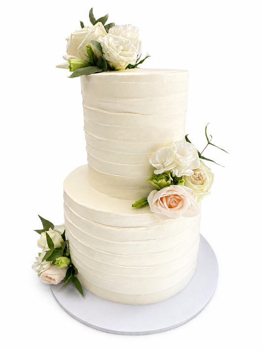 White textured wedding cake decorated with fresh blooms