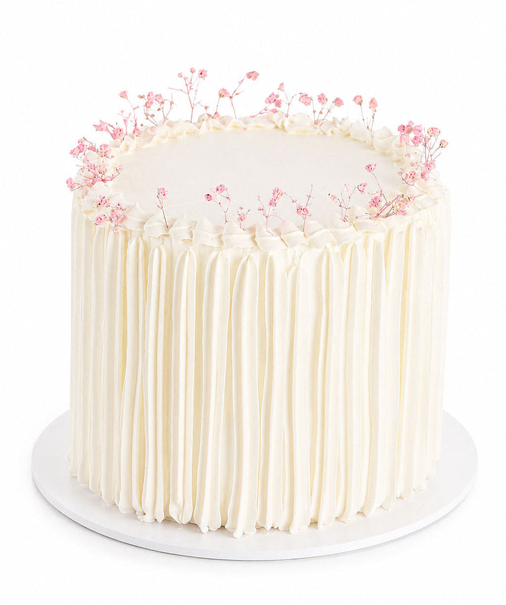 White minimalist buttercream cake decorated with delicate baby's breath flowers
