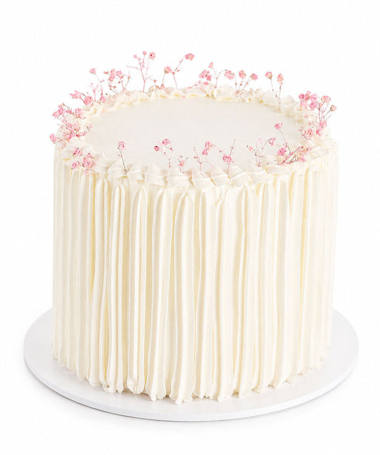 White minimalist buttercream cake decorated with delicate baby's breath flowers